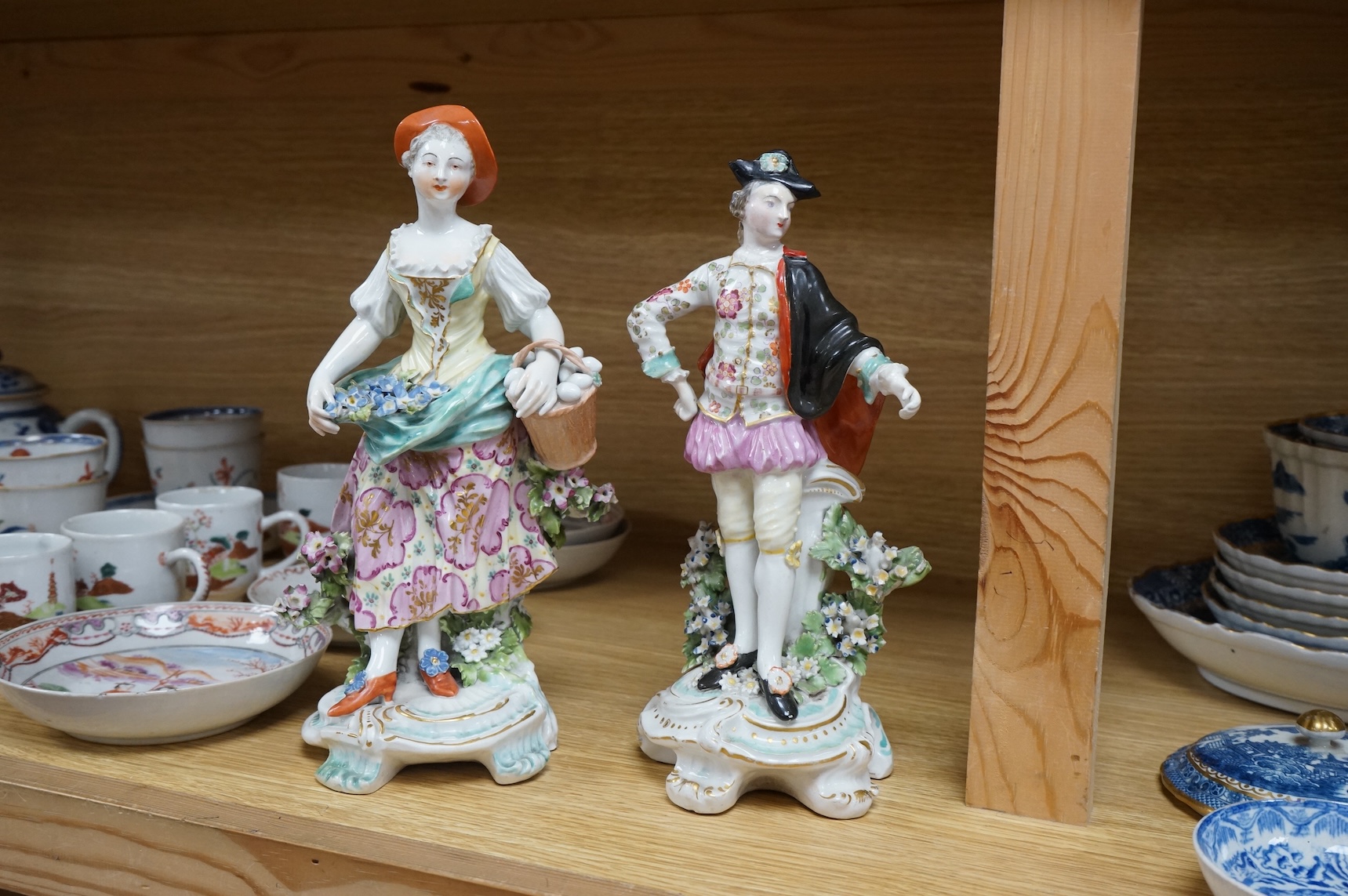 Three late 18th century Derby figures, a similar Derby figure of Summer, c.1810–30 and a Derby style figure of a street vendor, tallest 26cm high